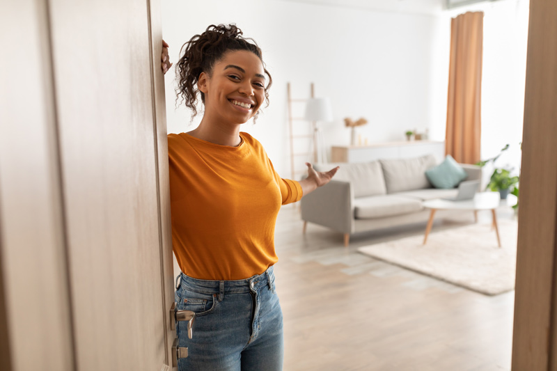 a woman opening a door into a new apartment